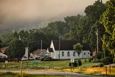 A foggy morning scene in Dakota, MN showcasing a quaint small town with green trees and classic architecture.